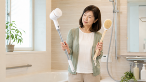 電動バスポリッシャーと手動のお風呂ブラシを比較する50代女性